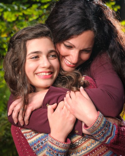 Mother and daughter hug portrait in the fall sun