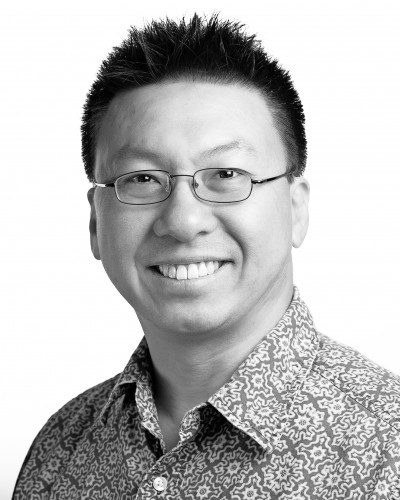 Black and white headshot of asian man smiling