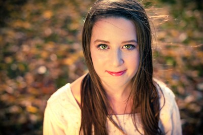 Beautiful girl senior portrait in the colorful fall leaves