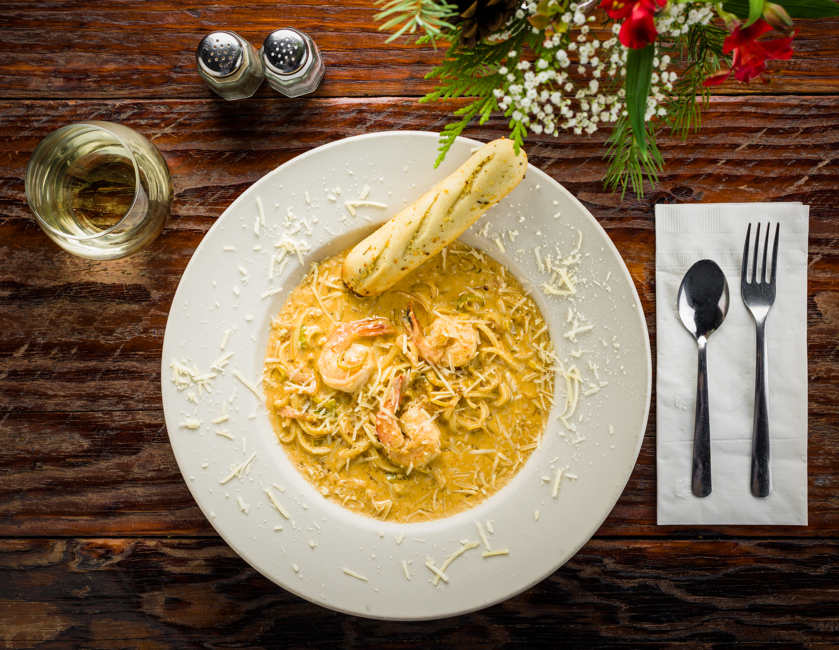 a bowl of spaghetti Alfredo shrimp and a breadstick